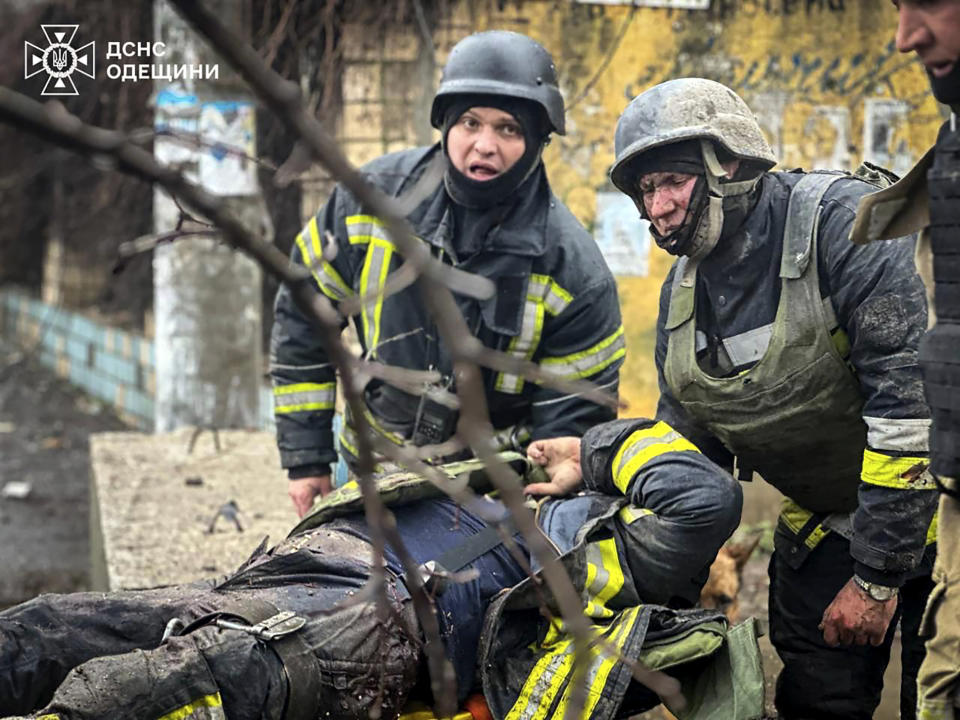 In this photo provided by the Ukrainian Emergency Service, emergency services help their comrade injured during a Russian attack in Odesa, Ukraine, Friday, March 15, 2024. A Russian missile strike on Odesa in southern Ukraine on Friday killed at least 14 people and injured 46 others, local officials said. (Ukrainian Emergency Service via AP)