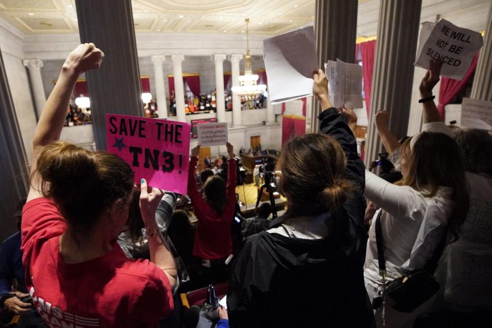 Gun reform and “Tennessee Three” supporters raise signs in the gallery of the House chamber Thursday, April 6, 2023, in Nashville, Tenn. Tennessee Republicans are seeking to oust three House Democrats for their role in a demonstration calling for gun control following the Nashville school shooting. (AP Photo/George Walker IV)