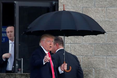 Republican presidential nominee Donald Trump arrives in the rain for a campaign rally in Tampa, Florida, U.S., August 24, 2016. REUTERS/Carlo Allegri