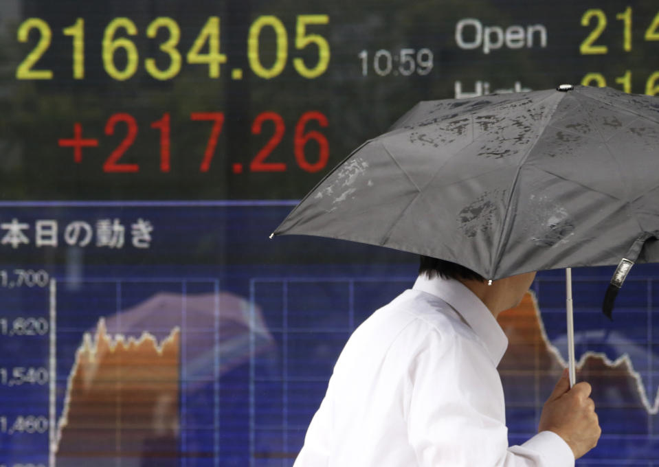 A man walks by an electronic stock board of a securities firm in Tokyo, Tuesday, July 23, 2019. Asian stock markets rose on Tuesday on optimism over possible new U.S.-China talks despite rising Middle East tensions. (AP Photo/Koji Sasahara)