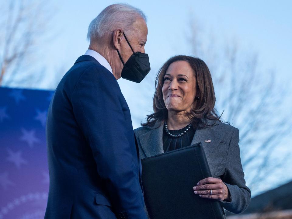 A masked Joe Biden is greeted by Kamala Harris after finishing her speech.