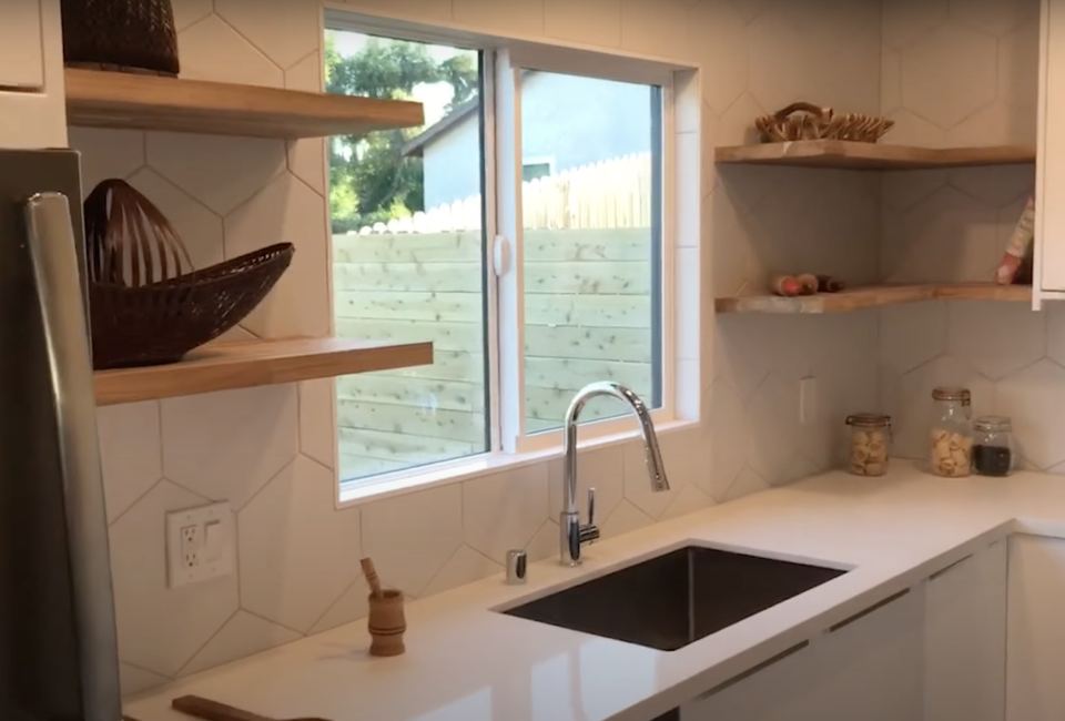 Open shelving in a white kitchen, with baskets on the shelves