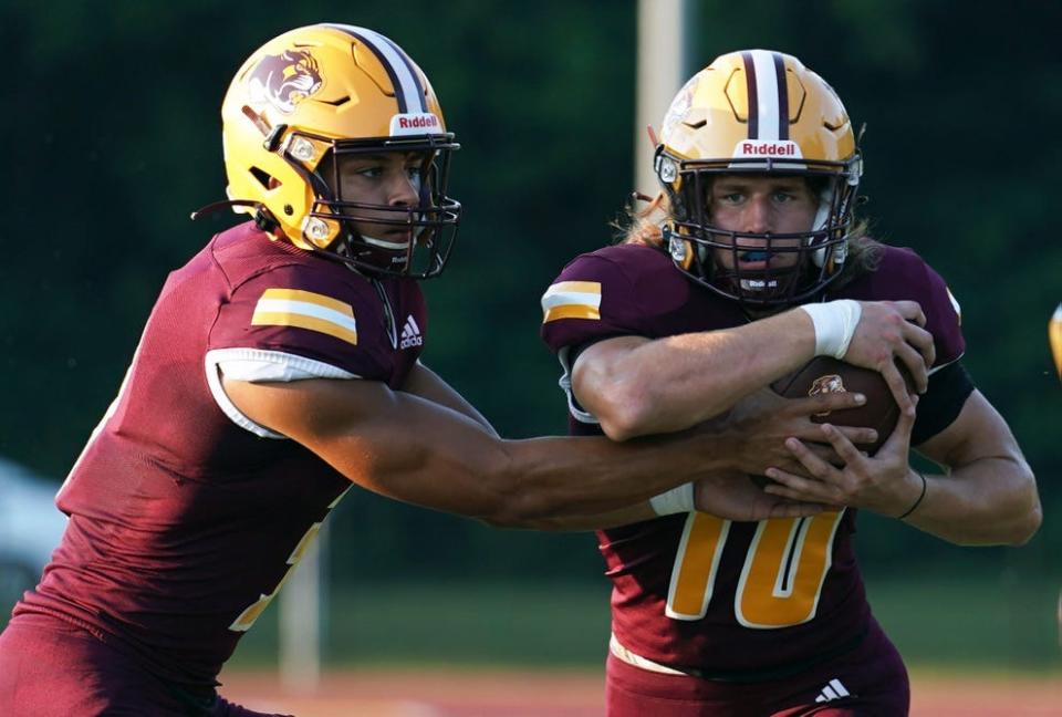 Bloomington North quarterback Reece Lozano hands the ball to tailback Cody Mikulich in last season's 48-8 romp over Greenwood.