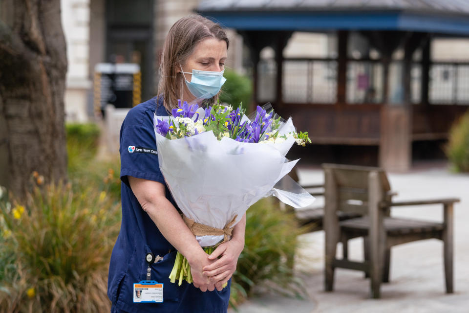 Staff at St Bartholomew's Hospital, London, receive flowers from Queen Elizabeth II on the anniversary of the first national lockdown to prevent the spread of coronavirus. Picture date: Tuesday March 23, 2021. (Photo by Dominic Lipinski/PA Images via Getty Images)