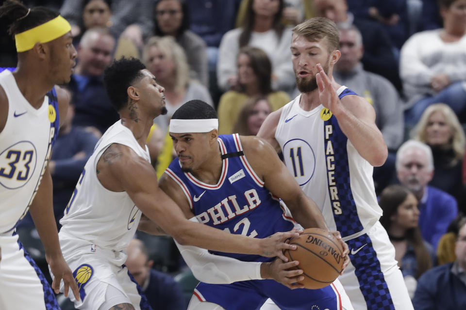 Philadelphia 76ers' Tobias Harris (12) is defended by Indiana Pacers' Jeremy Lamb (26) and Domantas Sabonis (11) during the first half of an NBA basketball game, Monday, Jan. 13, 2020, in Indianapolis. (AP Photo/Darron Cummings)