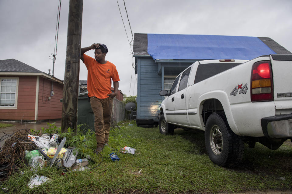 Standing in front of his house covered in a blue tarp from Hurricane Laura damage, Joshua Espree, 30, plans on staying in Lake Charles, La., and helping his family as Hurricane Delta approaches the area on Friday, Oct. 9, 2020. Delta is expected to make landfall late Friday. (Chris Granger /The Advocate via AP)