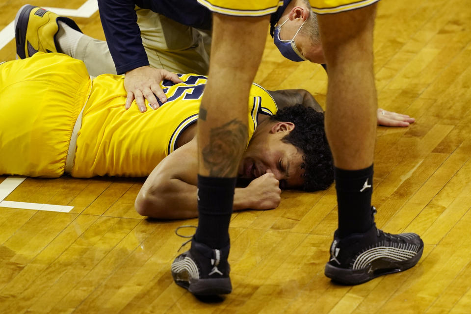 Michigan guard Eli Brooks is examined after a play during the first half of an NCAA college basketball game against Michigan State, Sunday, March 7, 2021, in East Lansing, Mich. (AP Photo/Carlos Osorio)