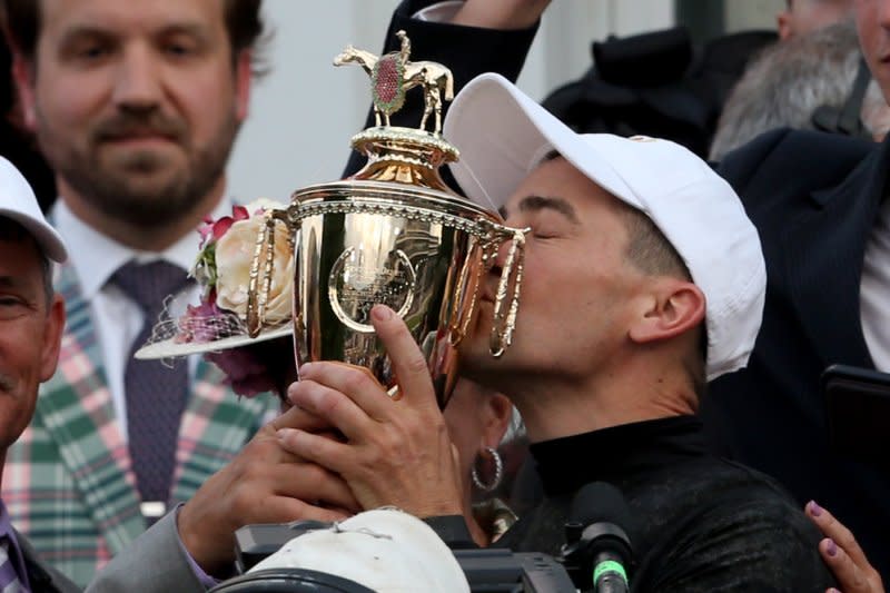 Jockey Brian Hernandez celebrates after winning 150th running of the Kentucky Derby aboard Mystick Dan by kissing the trophy at Churchill Downs on Saturday in Louisville, Ky. Photo by John Sommers II/UPI