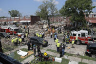 Rescue officials work near the rubble in the aftermath of an explosion in Baltimore, Monday, Aug. 10, 2020. Baltimore firefighters say an explosion has leveled several homes in the city. (AP Photo/Julio Cortez)