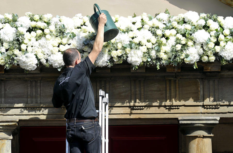 A man waters flowers at Canongate Kirk ahead of the wedding in Edinburgh, Scotland, on July 30, 2011, between Zara Phillips, granddaugter of Britain's Queen Elizabeth II, and England rugby star Mike Tindall. The couple, both world-beating sports stars, tie the knot at Edinburgh's Canongate Kirk in a private ceremony mid-afternoon that has little in common with that of Phillips' cousin, Prince William, when he married the former Kate Middleton three months ago. AFP PHOTO / Andy Buchanan (Photo credit should read Andy Buchanan/AFP via Getty Images)