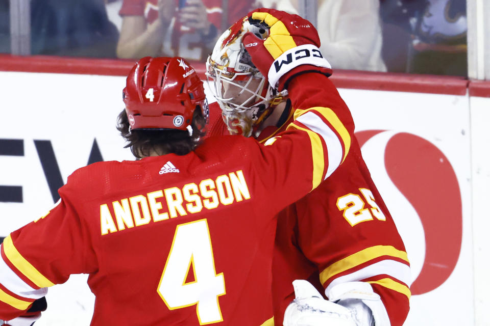 Calgary Flames goalie Jacob Markstrom, right, celebrates the team's 3-1 win over the Florida Panthers with teammate Rasmus Andersson after an NHL hockey game in Calgary, Alberta, Monday, Dec. 18, 2023. (Larry MacDougal/The Canadian Press via AP)