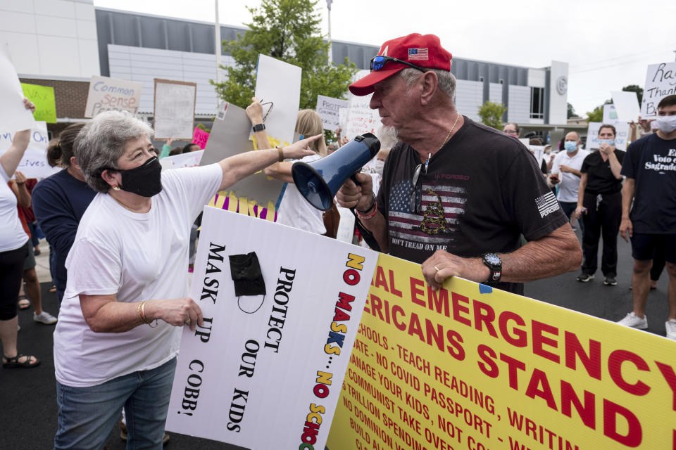 People in favor of and against a mask mandate for Cobb County schools gather and protest ahead of the school board meeting Thursday, Aug. 19, 2021, in Marietta, Ga. (Ben Gray/Atlanta Journal-Constitution via AP)