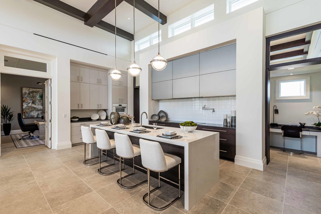 A gourmet-worthy kitchen with sleek-lined cabinetry features an ingenious walk-through office, pantry and wine room.