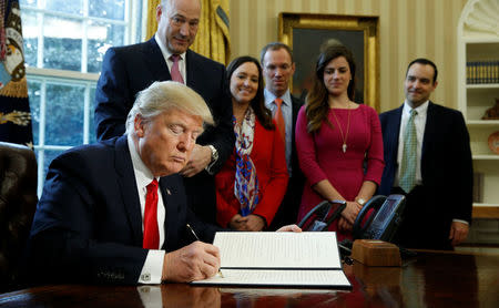 U.S. President Donald Trump signs an executive order rolling back regulations from the 2010 Dodd-Frank law on Wall Street reform at the White House in Washington February 3, 2017. REUTERS/Kevin Lamarque