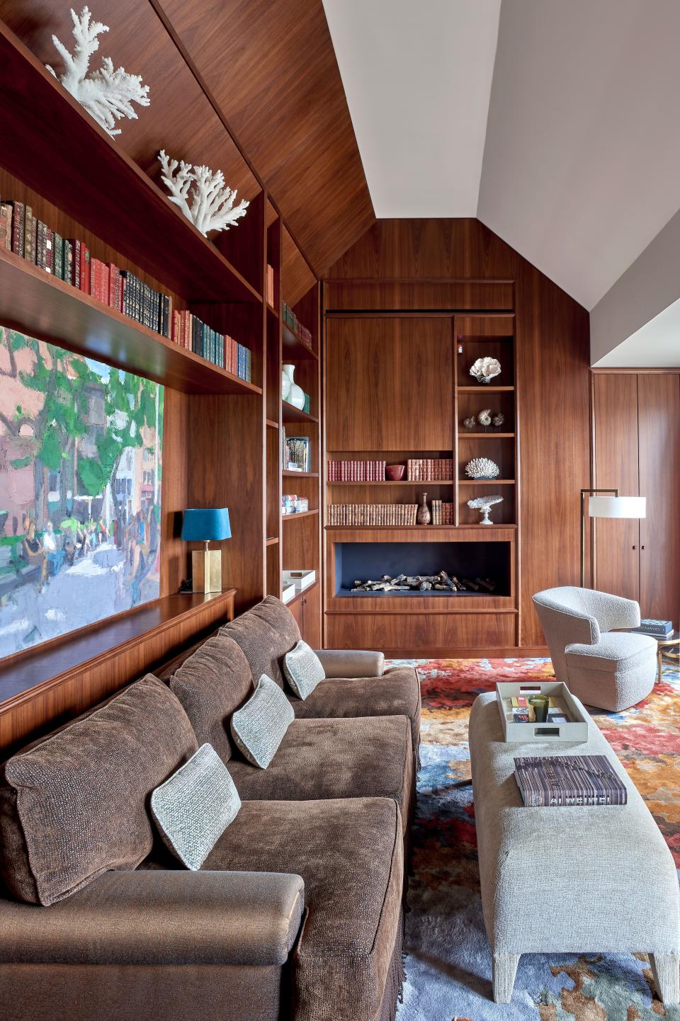 Two smaller rooms above the apartment’s main floor allowed for additional space to create this library with amazing views over the Invalides esplanade. The wall-to-wall carpet by Holland & Sherry and the Lana chair by Donghia. Sofa and ottoman in Rubelli fabric. The painting above the sofa is by American artist John Dubrow, and Laura Caye Decoration helped Wood hunt down items from the streets of Paris and the flea market. Wood explains, “This area provided a fun opportunity to create a cabinet of natural curiosities, with items sourced from Deyrolle and books.”