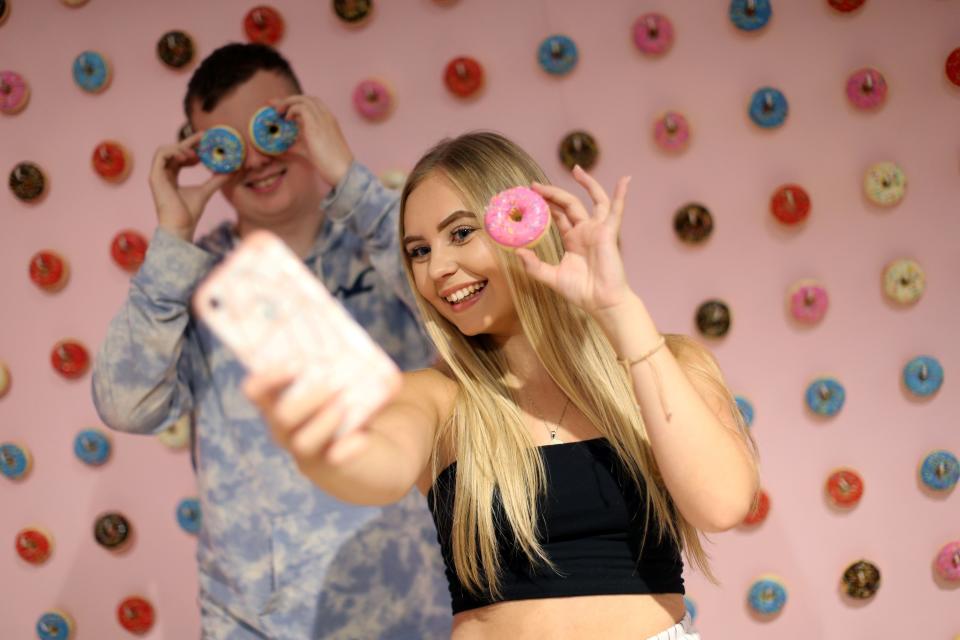 Visitors take and pose for "selfie" photographs at The Selfie Factory in Westfield London 