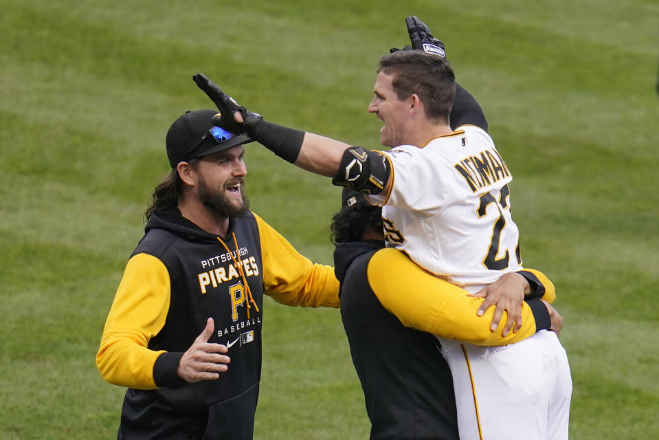 Pittsburgh Pirates' Kevin Newman, right, celebrates with teammates after hitting the game-winning RBi single off of Cincinnati Reds relief pitcher Alexis Diaz in the 10th inning of a baseball game in Pittsburgh, Wednesday, Sept. 28, 2022. The Pirates won 4-3 in 10 innings. (AP Photo/Gene J. Puskar)