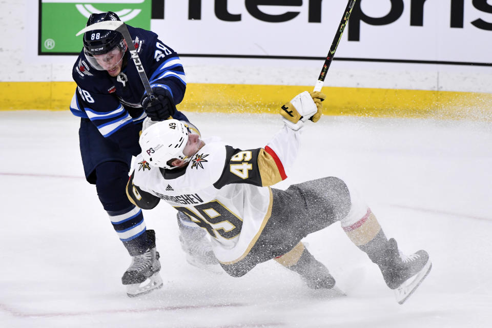 Winnipeg Jets' Nate Schmidt (88) checks Vegas Golden Knights' Ivan Barbashev (49) during first-period Game 4 NHL Stanley Cup first-round hockey playoff action in Winnipeg, Manitoba, Monday April 24, 2023. (Fred Greenslade/The Canadian Press via AP)