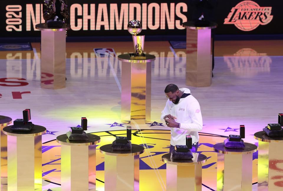 Lakers forward LeBron James puts on his NBA championship ring during a ceremony Dec. 22 at Staples Center.