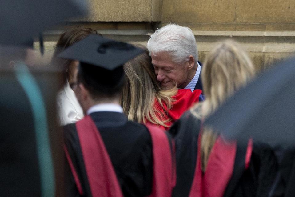 Former U.S. President Bill Clinton hugs his daughter Chelsea after attending her Oxford University graduation ceremony with his wife former Secretary of State Hillary Rodham Clinton held at the Sheldonian Theatre in Oxford, England, Saturday, May 10, 2014. Chelsea Clinton received her doctorate degree in international relations on Saturday from the prestigious British university. Her father was a Rhodes scholar at Oxford from 1968 to 1970. The graduation ceremony comes as her mother is considering a potential 2016 presidential campaign. (AP Photo/Matt Dunham)