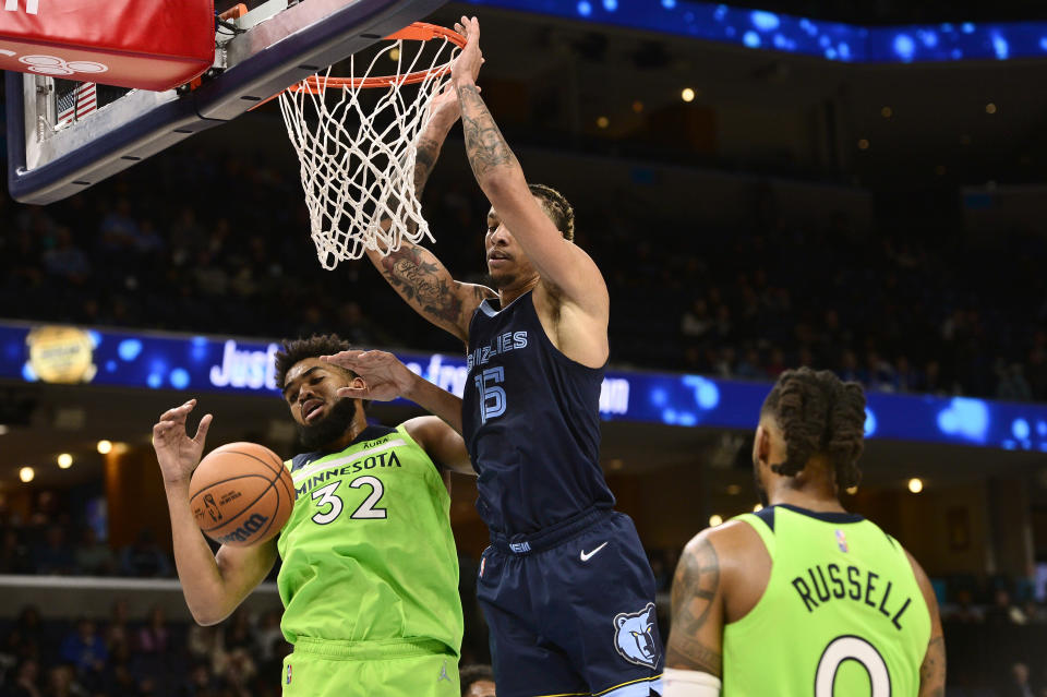 Memphis Grizzlies forward Brandon Clarke (15) scores against Minnesota Timberwolves center Karl-Anthony Towns (32) in the second half of an NBA basketball game Monday, Nov. 8, 2021, in Memphis, Tenn. (AP Photo/Brandon Dill)