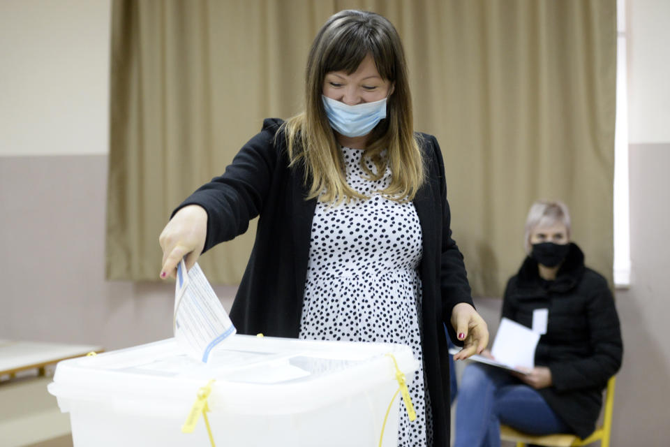 Irma Baralija casts her ballot for the local elections at a polling station in Mostar, Bosnia, Sunday, Dec. 20, 2020. Baralija hopes to win her race as the southern Bosnian city of Mostar holds its first local election in 12 years. (AP Photo/Kemal Softic)