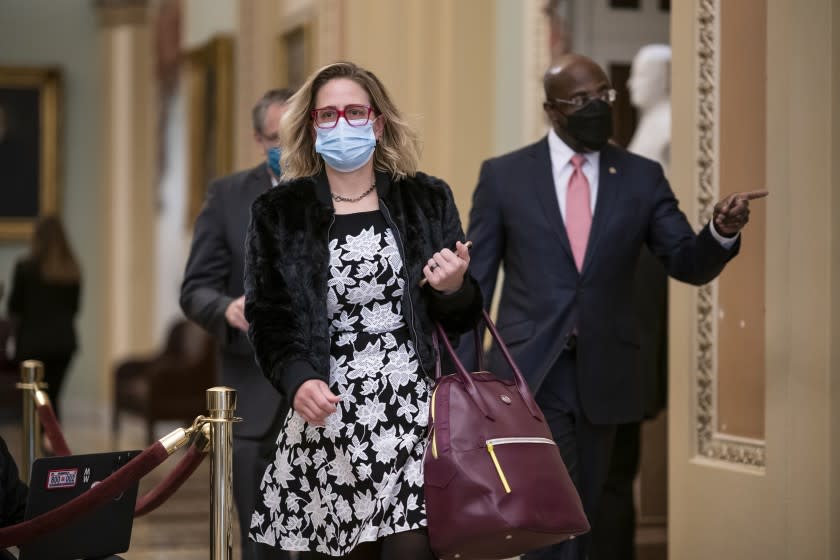 Sen. Kyrsten Sinema, D-Ariz., and Sen. Raphael Warnock, D-Ga., right, arrive as the second impeachment trial of former President Donald Trump starts in the Senate, at the Capitol in Washington, Tuesday, Feb. 9, 2021. (AP Photo/J. Scott Applewhite)