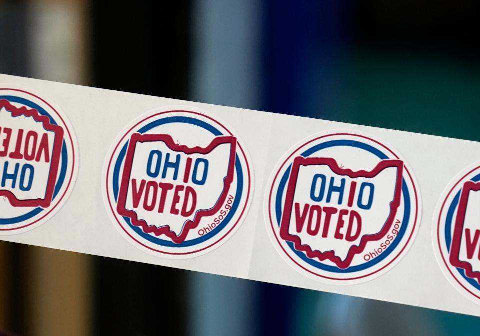 Nov. 8, 2022; Columbus, Ohio, USA; A poll worker holds up voting stickers inside Christ the King School on East Livingston Avenue in Berwick on the morning of Election Day, Tuesday, Nov. 8th. Mandatory Credit: Barbara J. Perenic/Columbus Dispatch