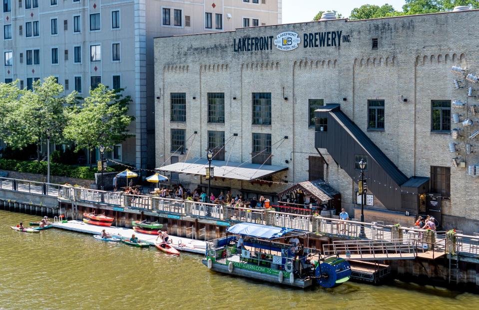 People dock their canoes by the Lakefront Brewery on Friday, July 22, 2022 on the Milwaukee River in Milwaukee, Wis.