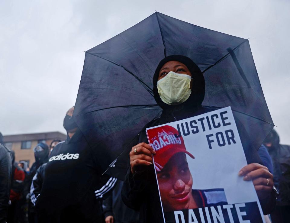 People gather at the start of the curfew to protest the death of Daunte Wright who was shot and killed by a police officer in Brooklyn Center, Minnesota on April 12, 2021.  A suburb of Minneapolis was under curfew early April 12, 2021 after US police fatally shot a young Black man, sparking protests not far from where a former police officer was on trial for the murder of George Floyd.Hundreds of people gathered outside the police station in Brooklyn Center, northwest of Minneapolis, with police later firing teargas and flash bangs to disperse the crowd, according to an AFP vide ojournalist.