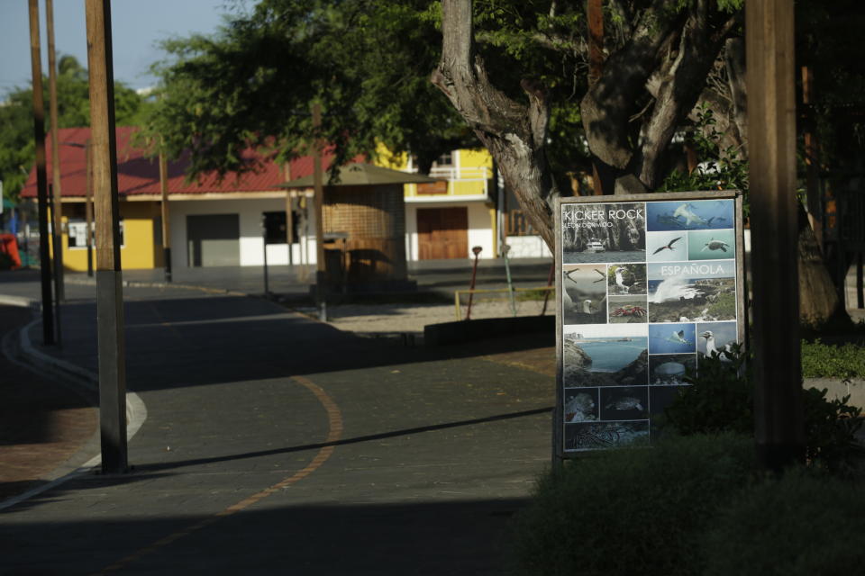In this May 2, 2020 photo, the sun shines on a poster advertising island tours and shuttered businesses ordered closed by the government as a measure to curb the spread of the new coronavirus, in San Cristobal, Galapagos Islands, Ecuador. Ecuador is among Latin American nations hit hardest by COVID-19. (AP Photo/Adrian Vasquez)