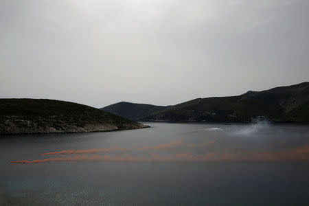 Locals on a boat light up flares to celebrate the baptism of the first baby born on the islet of Thymaina after six years, with the financial support of the Aegean Team doctors, on the islet of Ayios Minas, Greece, May 12, 2017. REUTERS/Alkis Konstantinidis