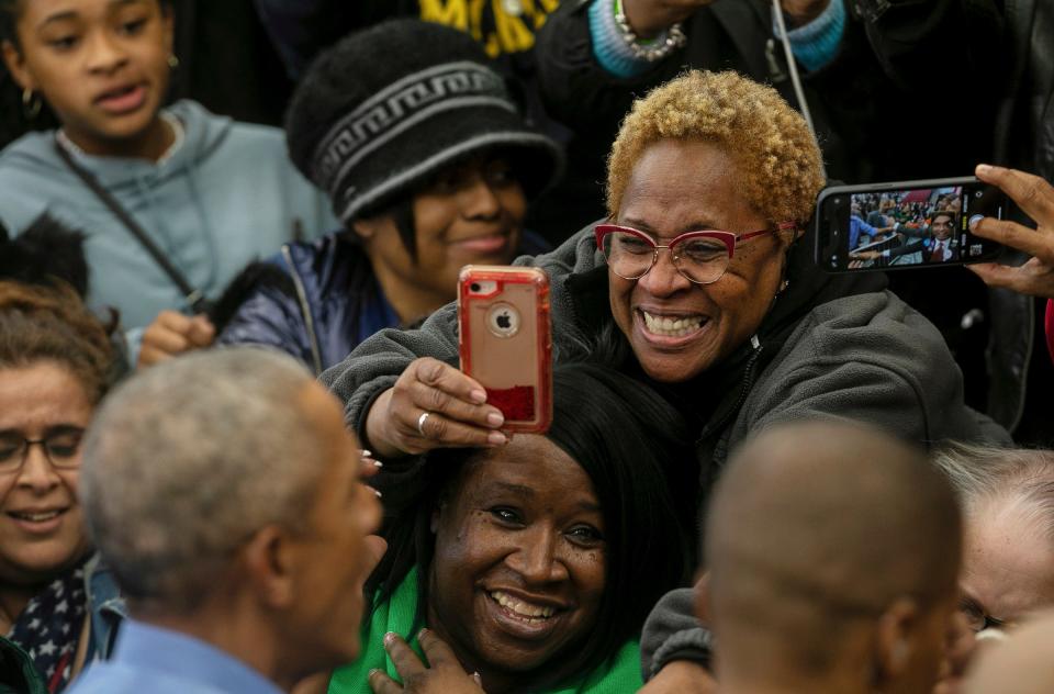 People smile as they greet former President Barack Obama during a rally at Renaissance High School in Detroit on Saturday, Oct. 29, 2022. 