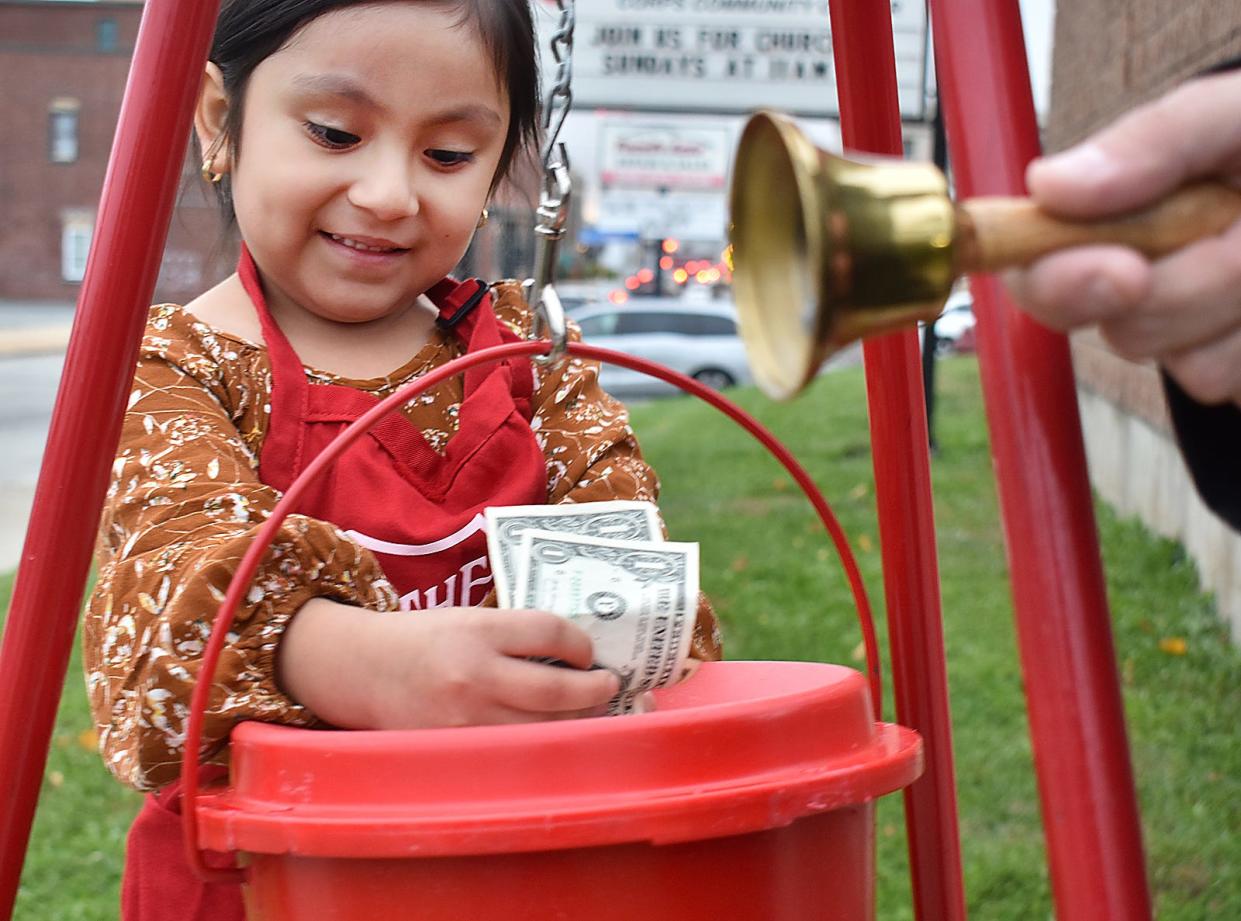 Abigail Parra drops a monetary donation into The Salvation Army's kettle in Fall River, Mass., Monday Nov. 6, 2023.