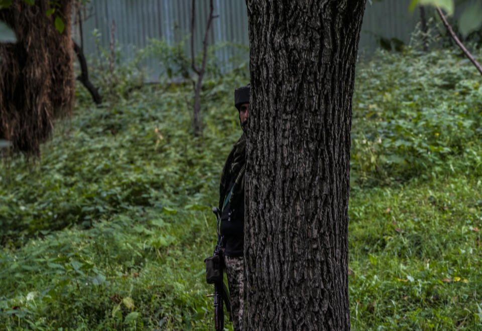 A soldier keeps guard near the site of attack on Sunil Kumar, a Kashmiri Hindu man locally known as Pandit, at Chotigam village, some 62 kilometers south of Srinagar, Indian controlled Kashmir, Tuesday, Aug. 16, 2022. Pandit was shot dead by suspected rebels at an apple orchard on Tuesday morning, while his brother was injured in the attack, officials said. (AP Photo/Mukhtar Khan)