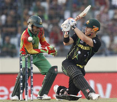 Australia's David Warner (R) plays a ball as Bangladesh's captain and wicketkeeper Mushfiqur Rahim tries to catch during their ICC Twenty20 World Cup match at the Sher-E-Bangla National Cricket Stadium in Dhaka April 1, 2014. REUTERS/Andrew Biraj