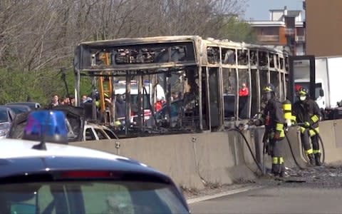 The burnt-out bus on a highway near Milan - Credit: Reuters