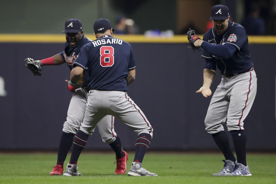 Atlanta Braves right fielder Jorge Soler, from left, left fielder Eddie Rosario and and left fielder Adam Duvall celebrate their win against the Milwaukee Brewers in Game 2 of baseball's National League Divisional Series Saturday, Oct. 9, 2021, in Milwaukee.(AP Photo/Aaron Gash)