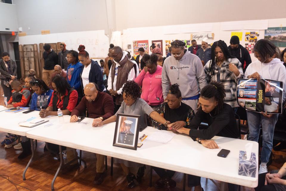 Family members of Christopher Kelley and Taylor Lowery hold hands and bow their heads in prayer following a news conference Sunday afternoon at Faith Temple Church, 1162 S.W. Lincoln. The families, along with legal representatives and community activists, are asking Topeka's city government to release the body cam footage of officer-involved fatal shootings.