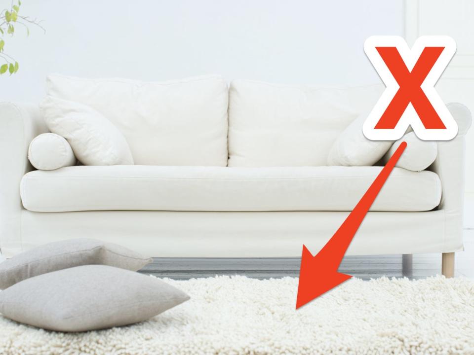 red x and arrow pointing at white carpet in a living room