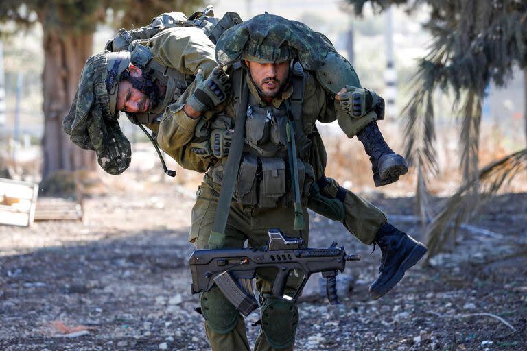 Un soldado israelí lleva a un colega mientras entrena mientras mantiene una posición en la región de la Alta Galilea en el norte de Israel, cerca de la frontera con el Líbano, el 8 de noviembre de 2023