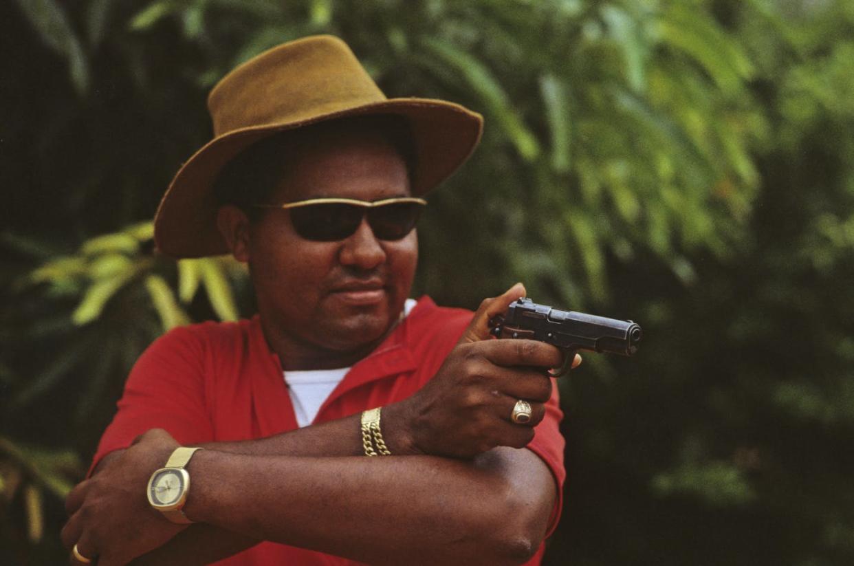<span class="caption">A marijuana trafficker practicing his aim in the Guajira, epicenter of Colombia's first drug boom, in 1979.</span> <span class="attribution"><a class="link " href="https://www.gettyimages.com/detail/news-photo/colombia-marijuana-dealer-practising-shooting-his-gun-on-news-photo/96345506?adppopup=true" rel="nofollow noopener" target="_blank" data-ylk="slk:Romano Cagnoni/Getty Images;elm:context_link;itc:0;sec:content-canvas">Romano Cagnoni/Getty Images</a></span>