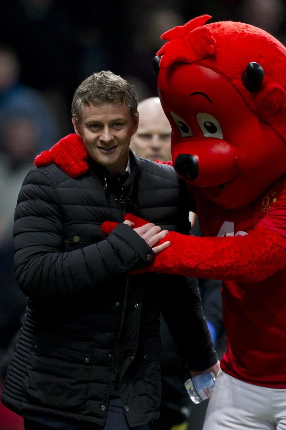 Cardiff City's manager Ole Gunnar Solskjaer is greeted by the Manchester United mascot as he takes to the touchline before his team's English Premier League soccer match against Manchester United at Old Trafford Stadium, Manchester, England, Tuesday Jan. 28, 2014. (AP Photo/Jon Super)