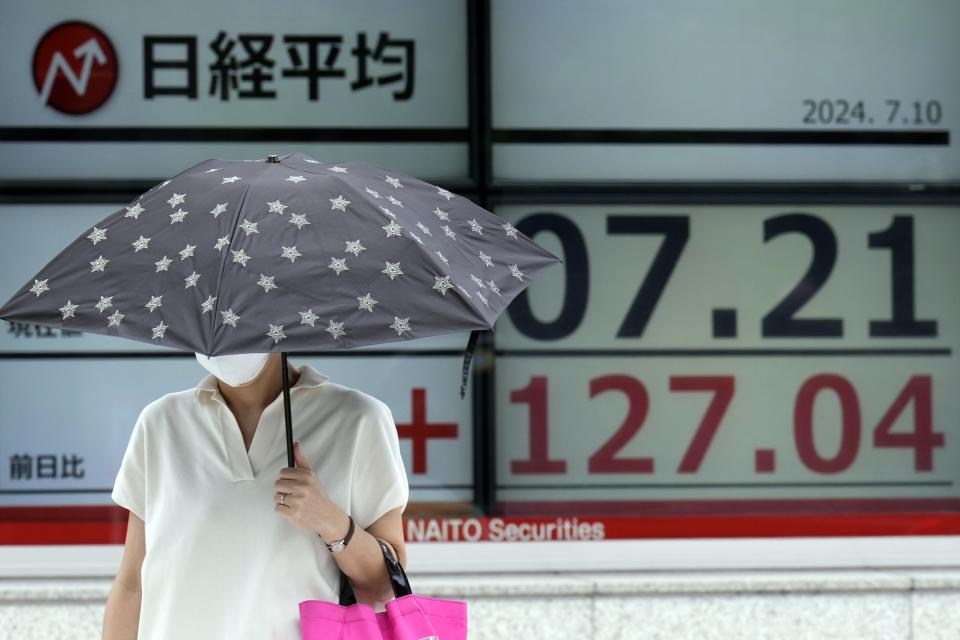 A person walks in front of an electronic stock board showing Japan's Nikkei index at a securities firm Wednesday, July 10, 2024, in Tokyo. (AP Photo/Eugene Hoshiko)