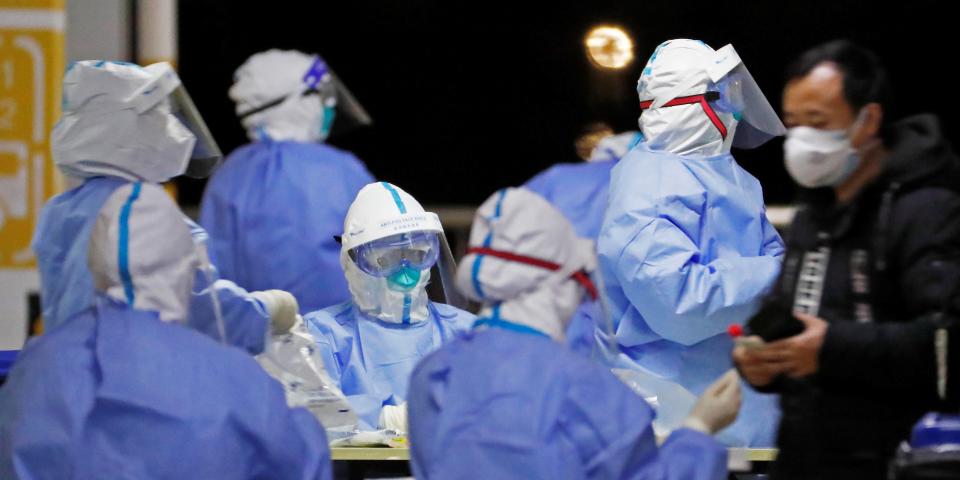 This photo taken on November 22, 2020 shows health workers in protective suits waiting to conduct COVID-19 coronavirus tests on staff at Pudong Airport in Shanghai. (Photo by STR / CNS / AFP) / China OUT (Photo by STR/CNS/AFP via Getty Images)