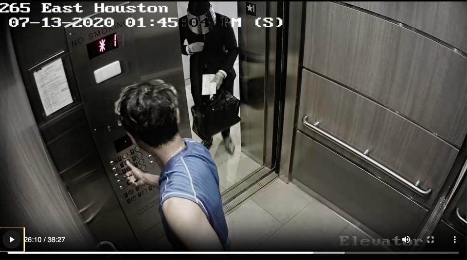 Fahim Saleh pressing a button in an elevator while Tyrese Haspil is in the elevator doorway, wearing a visor.