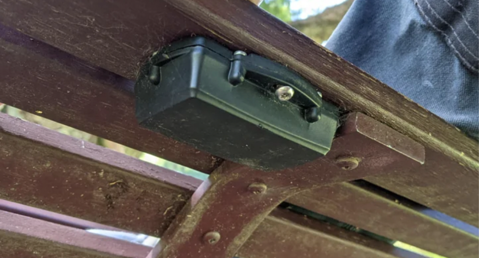 A small green box appears under a Melbourne park bench in the Royal Botanic Gardens.