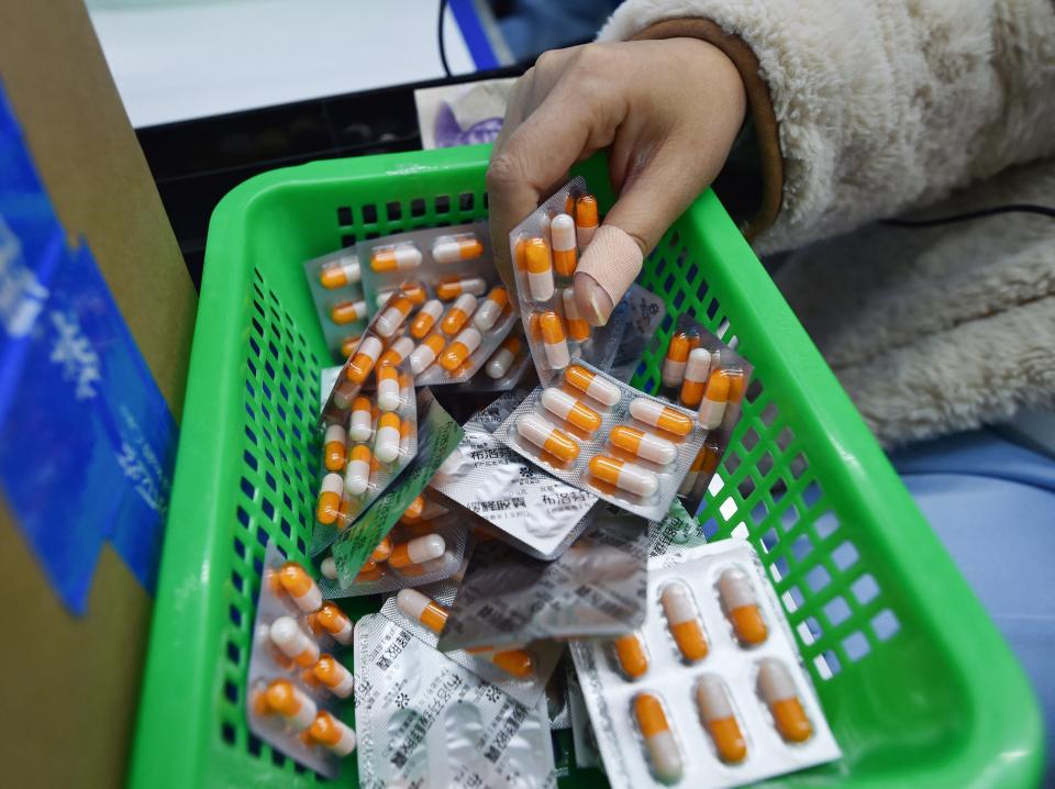 A staff member packing medication at a pharmacy in China.