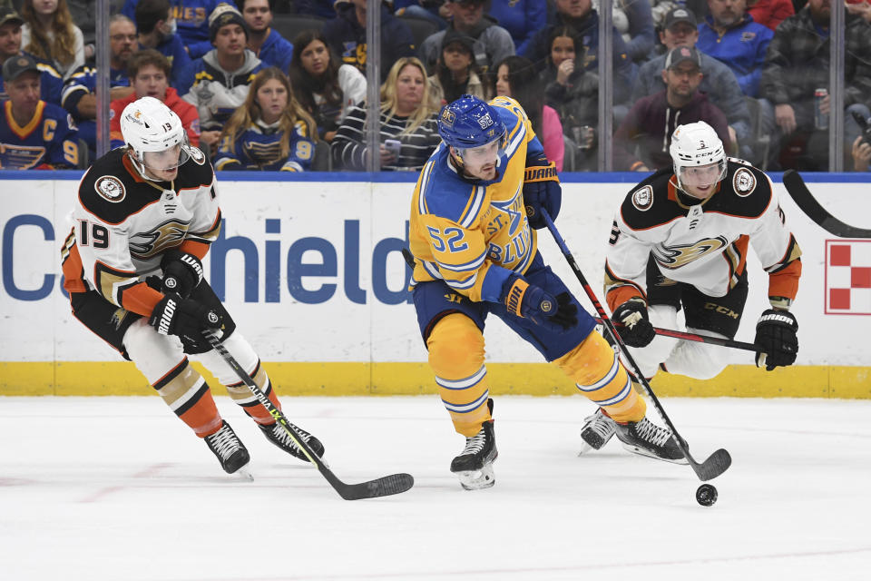 St. Louis Blues center Noel Acciari (52) works the puck against Anaheim Ducks' Troy Terry (19) and Jakob Silfverberg (33) during the second period of an NHL hockey game Monday, Nov. 21, 2022, in St. Louis. (AP Photo/Michael Thomas)