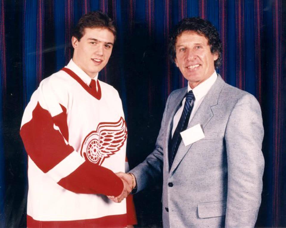 A young Steve Yzerman and Wings owner Mike Ilitch shake hands in a 1983 photo from Yzerman's rookie year with the Red Wings.